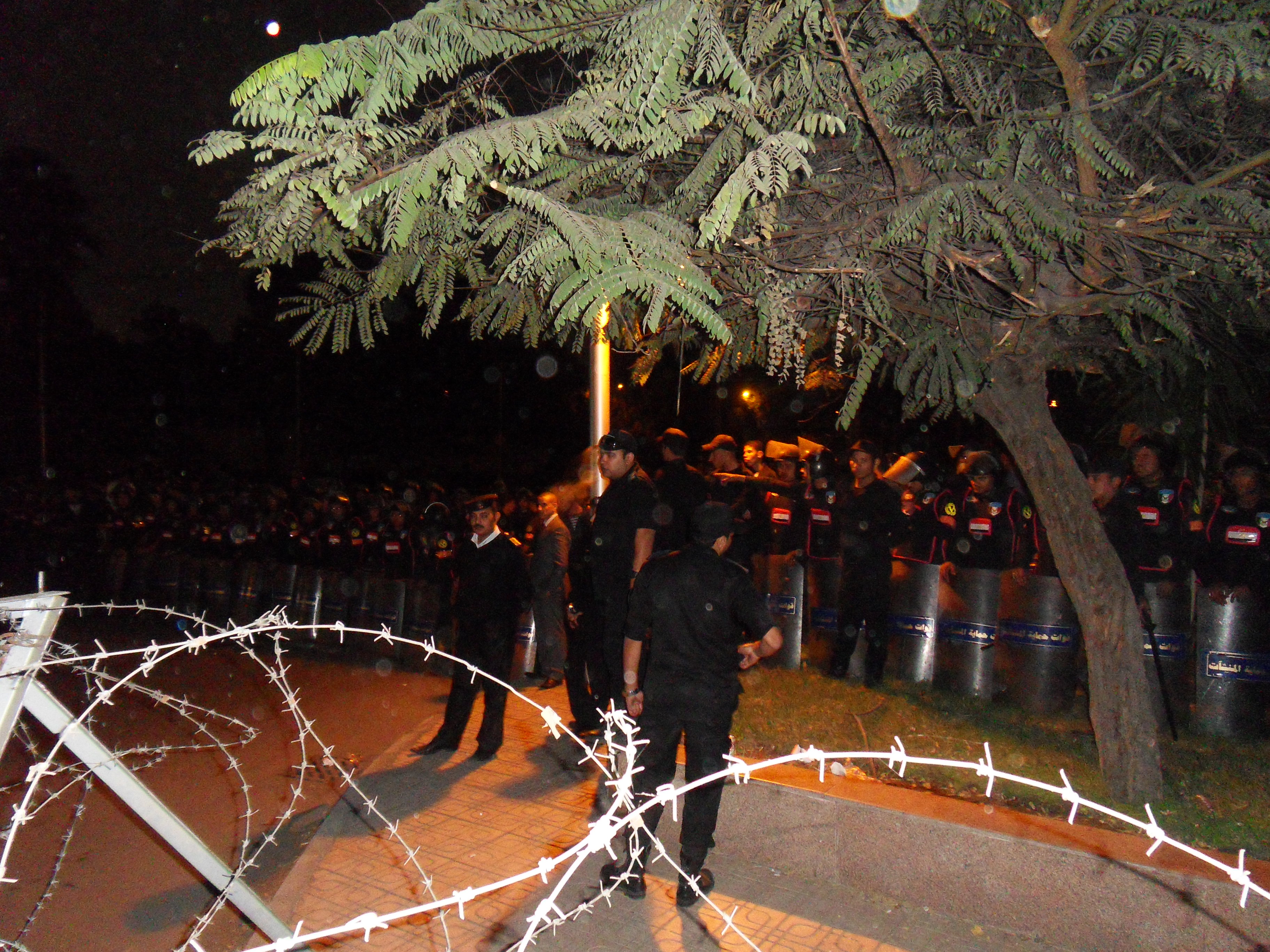 Security Forces blocking the road. People were talking with the officers across the barbed wire.