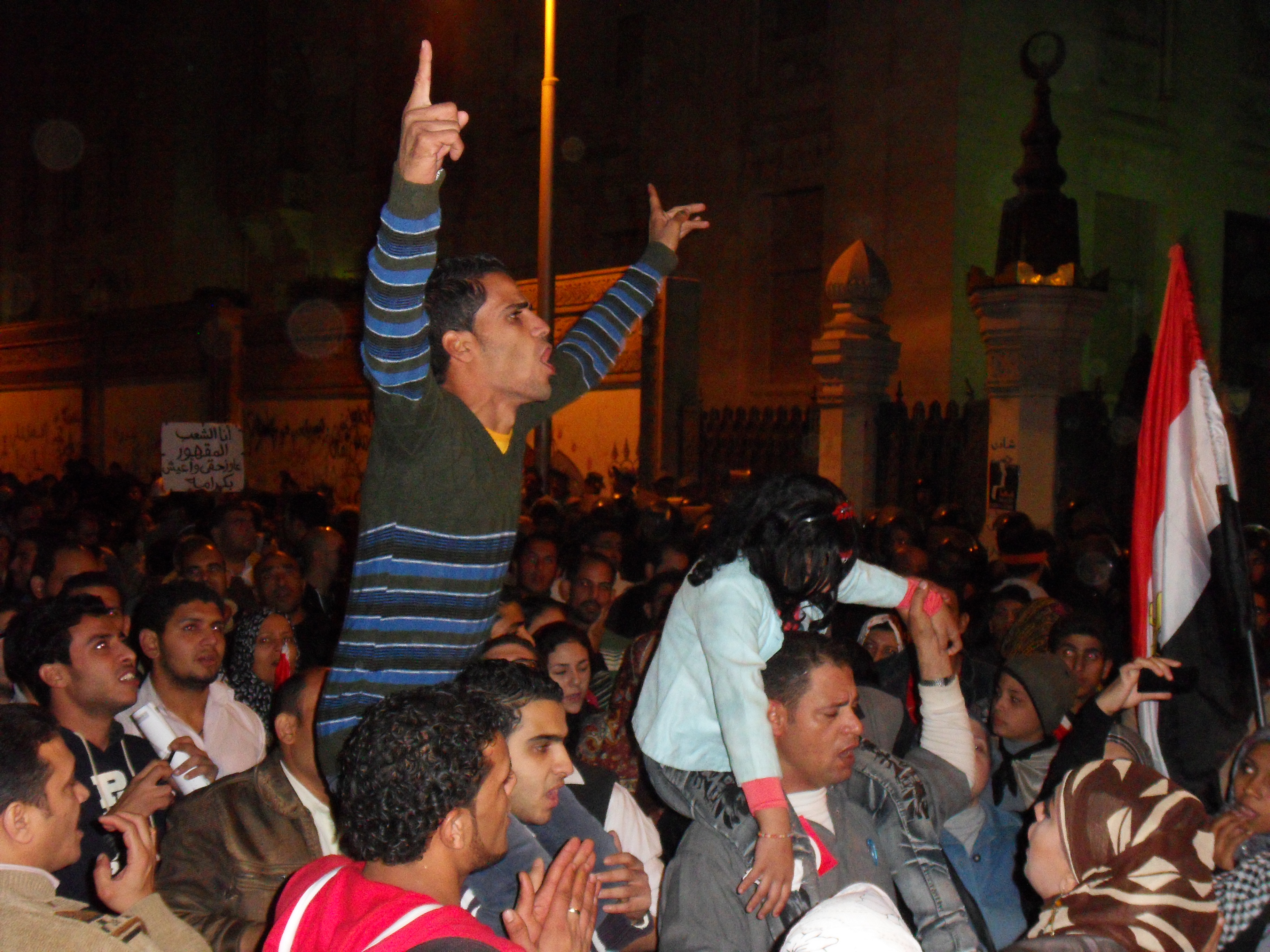 A man riling up the crowd against Morsi in front of the Palace's entrance.
