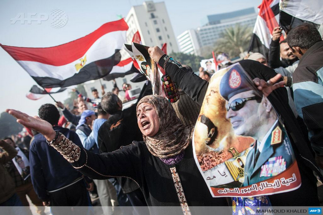 A woman holds up a poster of Field Marshall Abdel Fattah Al-Sisi during the third anniversary of the January 25 revolution.
