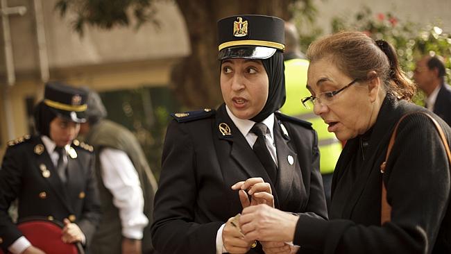 An Egyptian policewoman directs a woman at a polling station during voting on Egypt's latest constitution in 2014. Credit: AP