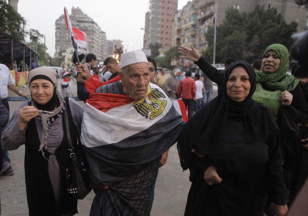 An Egyptian voter heads to the poll with an Egyptian flag wrapped around him. Credit: AP