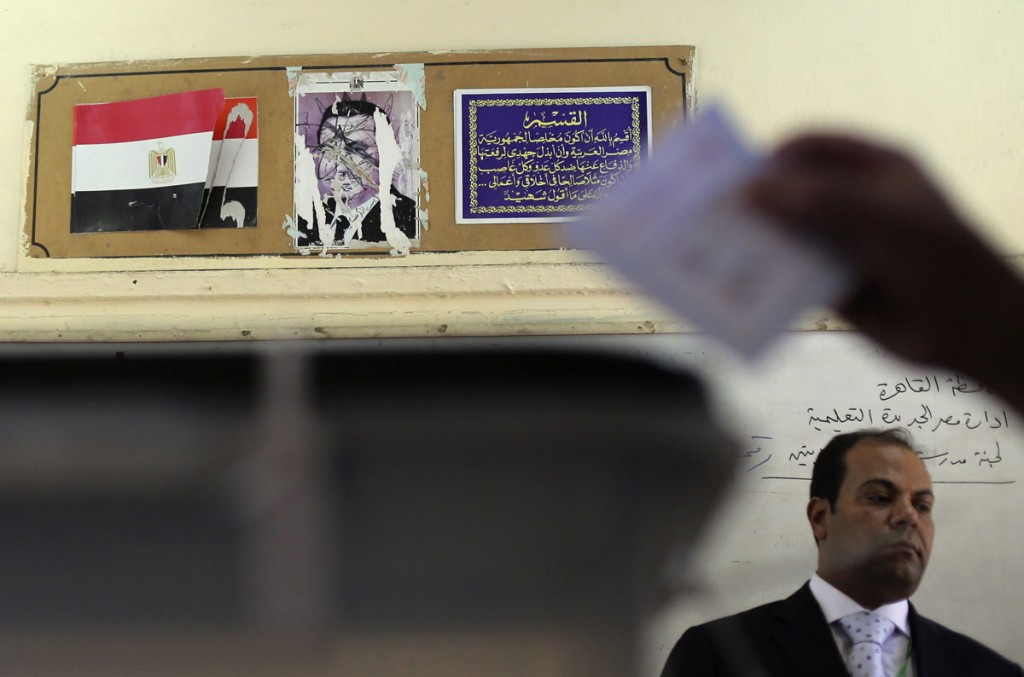 A scratched out photograph of former President Hosni Mubarak hangs at a polling station during the 2014 Presidential elections in Egypt.