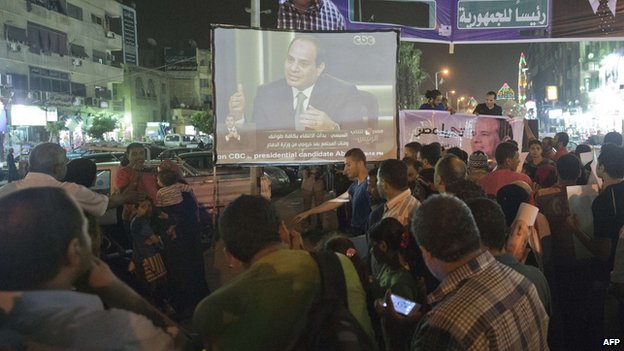 Egyptians gather on the streets of Cairo to watch Sisi's interview.
