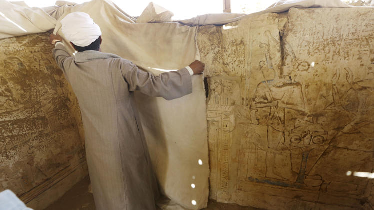 An archaeology worker covers limestones at a newly-discovered tomb in Saqqara. Credit: Amr Nabil/AP
