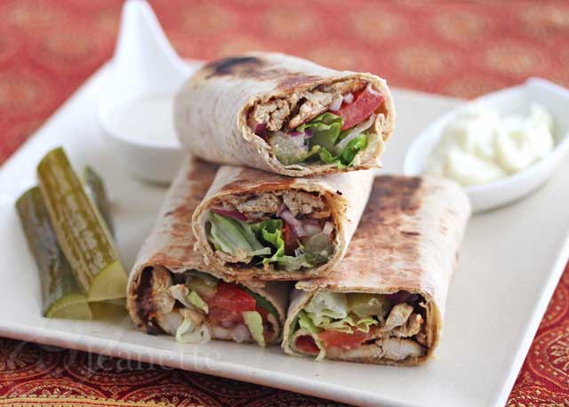 A chicken shawarma wrap served with pickled cucumbers. 