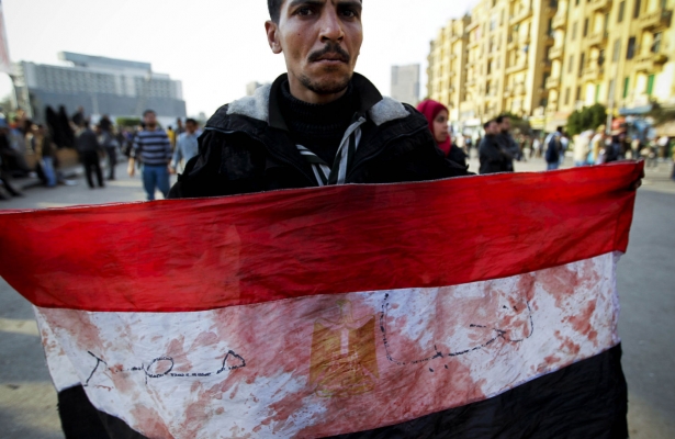 An Egyptian holds a flag spotted with blood during the January 25 revolution in 2011. Credit: AP/Todras-Whitehill