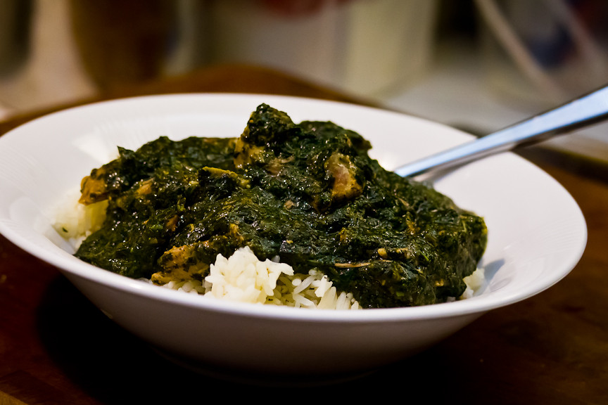 Green leafy mulukhiya soup poured over rice.