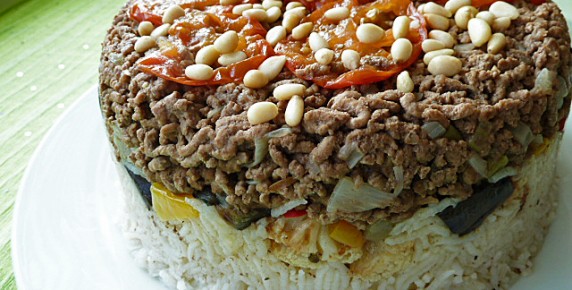 After the dish is flipped upside-down, it is garnished with pine nuts. 