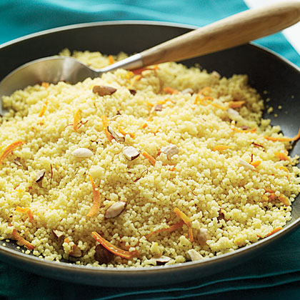 A coucous savory safron dish garnished with nuts and carrots,