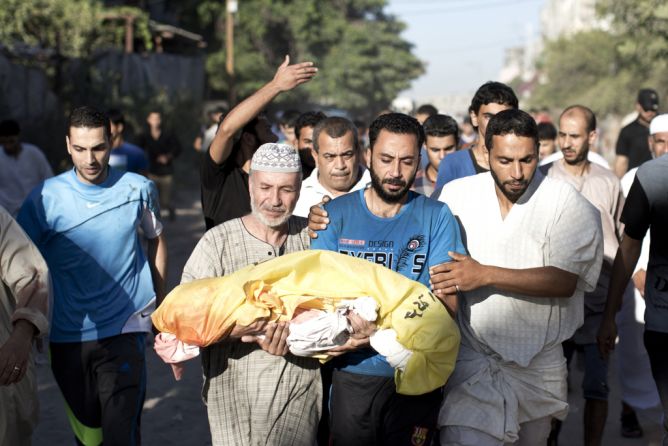 Palestinian mourners carry the body of four-year-old boy Sahir Abu Namus, during his funeral in Jabalia refugee camp in the northern Gaza Strip on July 11, 2014, after he was killed following an Israeli air strike. Israel's aerial bombardment of Gaza claimed its 103rd Palestinian life as Hamas pounded central Israel with rockets and Washington offered to help broker a truce. (MAHMUD HAMS/AFP/Getty Images)