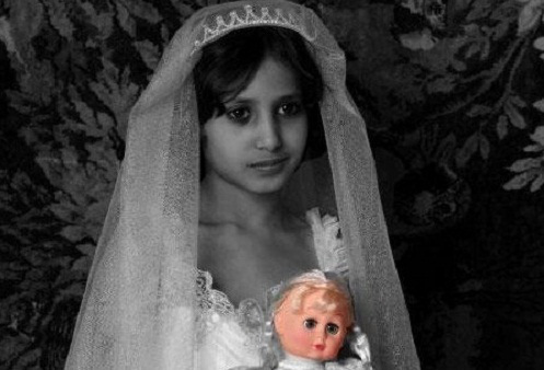 A child bride holding her doll. 