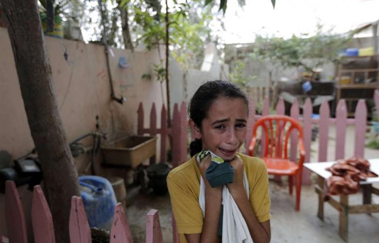The sister of medic Fuad Jaber, who was killed while on duty in Gaza's eastern Shujayeh district, mourns during his funeral in Gaza City on July 20, 2014. (Photo: AFP - Mohammed Abed)
