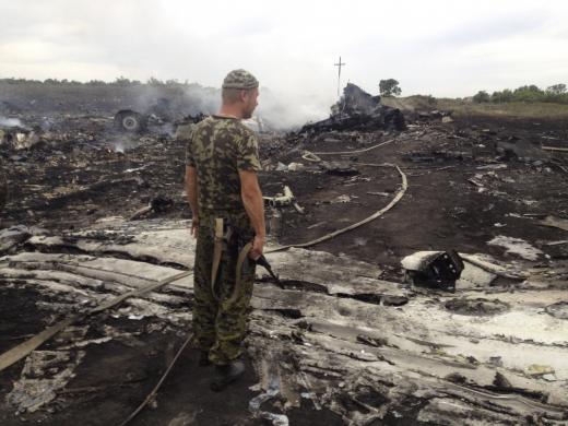 An armed pro-Russian separatist stands at the site of a Malaysia Airlines Boeing 777 plane crash in the settlement of Grabovo in the Donetsk region, July 17, 2014.  REUTERS/Maxim Zmeyev