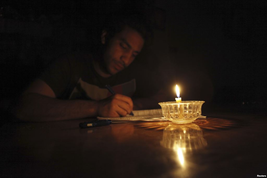 A student studies by candlelight during a power cut in May 2013. Credit: Reuters