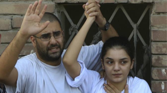 Surrounded by plainclothes policemen, Egyptian prominent blogger Alaa Abdel-Fattah, left, speaks to the crowd after attending, with his sister Sanaa, right, their father Ahmed Seif funeral in Cairo, Egypt, 28 August 2014. (Photo: AP)