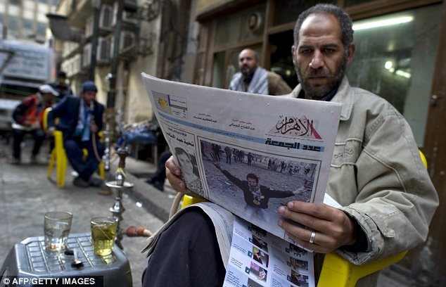 A man reads Egypt's state-owned Al-Ahram during the January 25 revolution. Credit: AFP