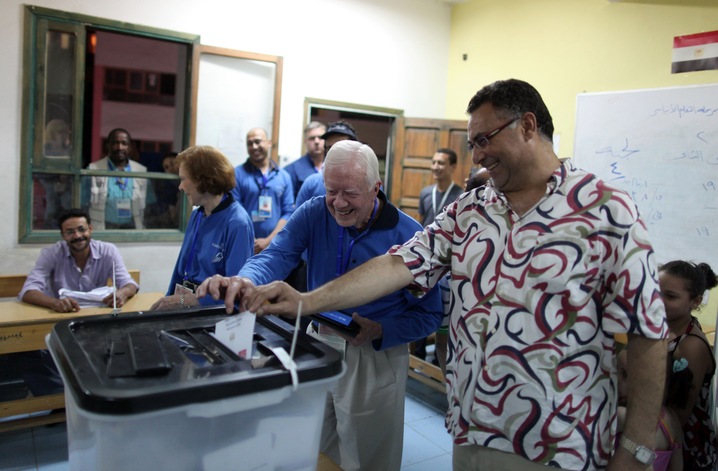 Former President Carter helps an Egyptian voter at a polling station in Cairo during the first round of presidential elections. in 2012. Photo by Wissam Saleh/AFP/Getty Images.