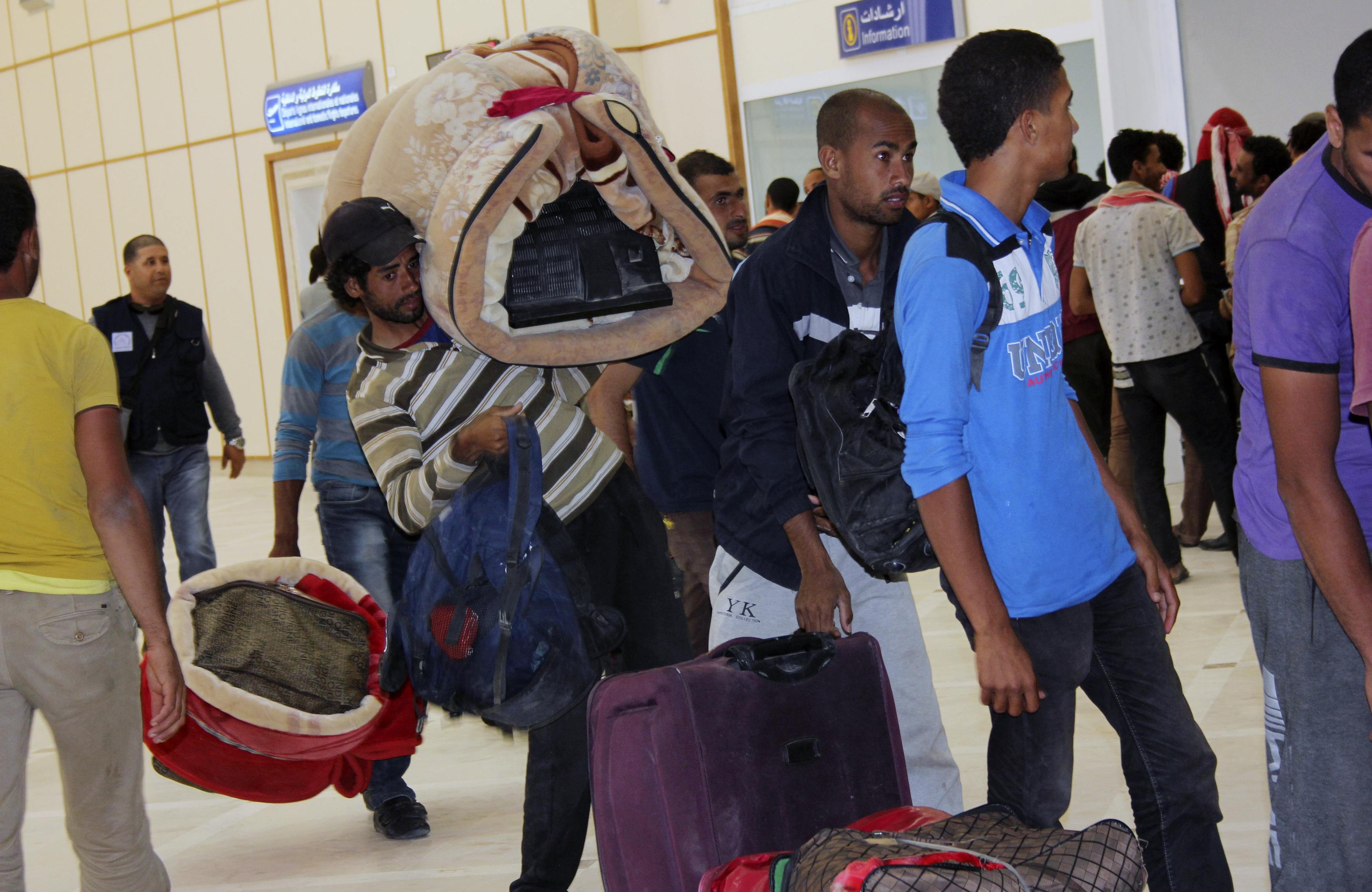 Egyptian men wait to board their plane to return home, at the Gabes Matmata airport, south of Tunisia
