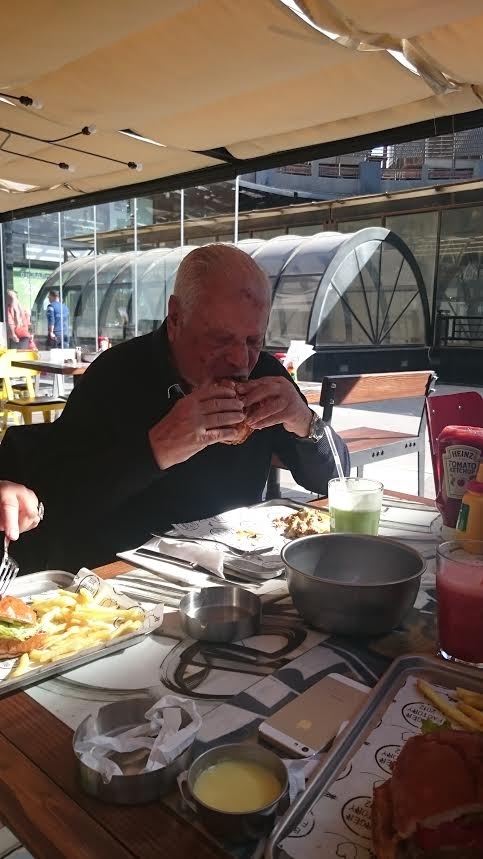 Grandfather munching away at his 'Cheezy Cheese' burger