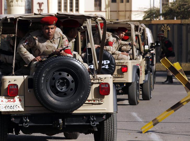 Soldiers in a convoy secure a military funeral ceremony of security personnel killed in attacks in Sinai, outside Almaza military airbase where the funerals were held, in Cairo