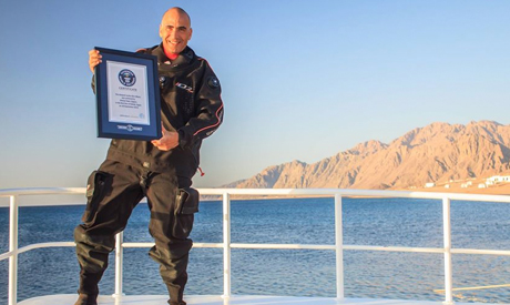 Gabr holding the Guinness World Record certificate for the deepest scuba dive