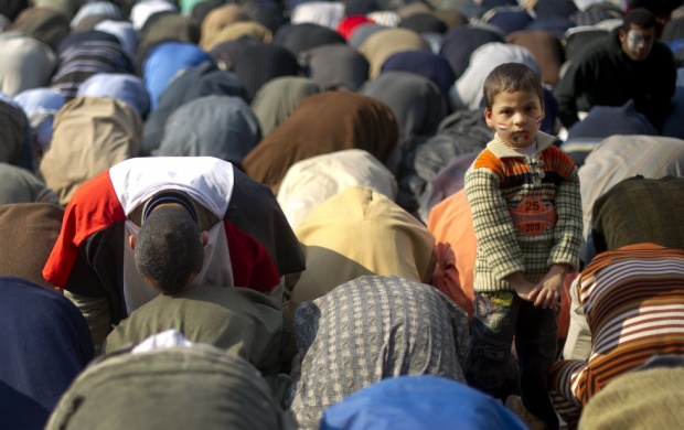 A young boy stands as anti-military rule protestors pray before a demonstration at Tahrir square in Cairo. Credit: AFP