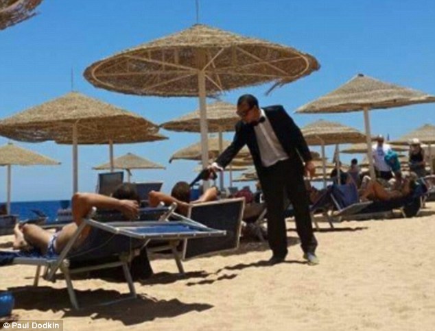 Entertainer at a Red Sea resort pointing a fake gun at British tourist days after the Sousse attack in Tunisia. Credit: Paul Dodkin