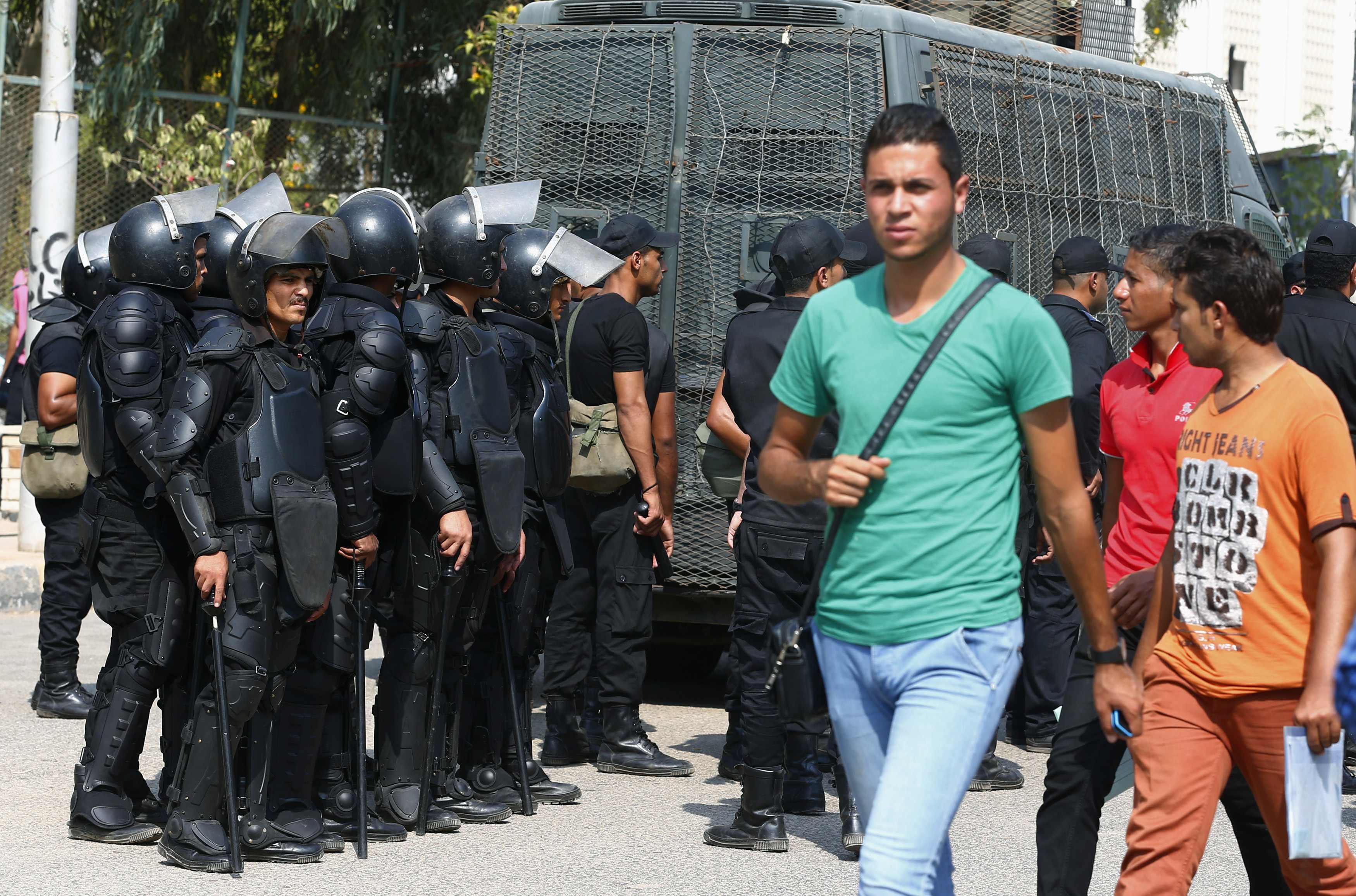 Al-Azhar University students walk past riot police during a protest conducted by the pro-Muslim Brotherhood student movement,  Students Against the Coup, October 12, 2014. Credit: Amr Abdallah Dalsh/Reuters