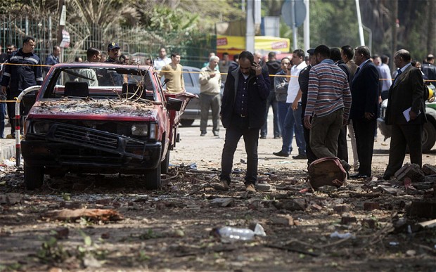 Egyptians inspect the damage after twin bombs struck police posts near Cairo University in April 2014. Credit: AFP