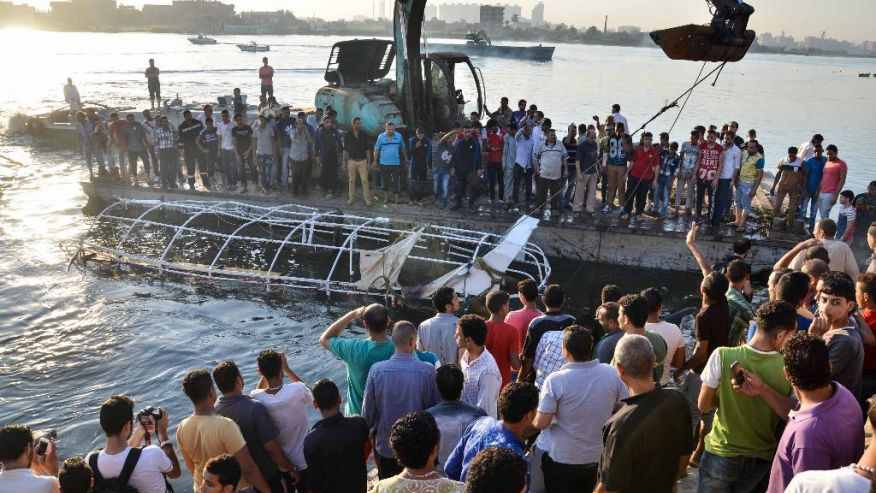 Egyptians look at the passenger boat that sunk in the river Nile in Giza, south of Cairo, Egypt, Thursday, July 23, 2015.  (AP Photo/Samer Abdullah)