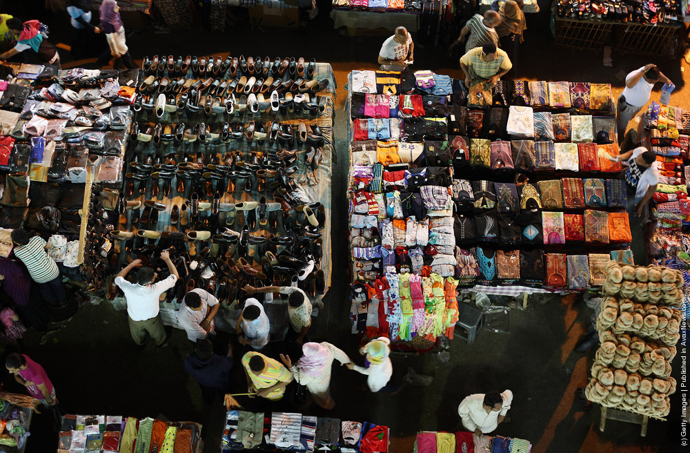 Shoppers move among tables containing clothes and shoes at Ataba market  in Cairo, Egypt. Credit: Peter Macdiarmid/ Getty Images