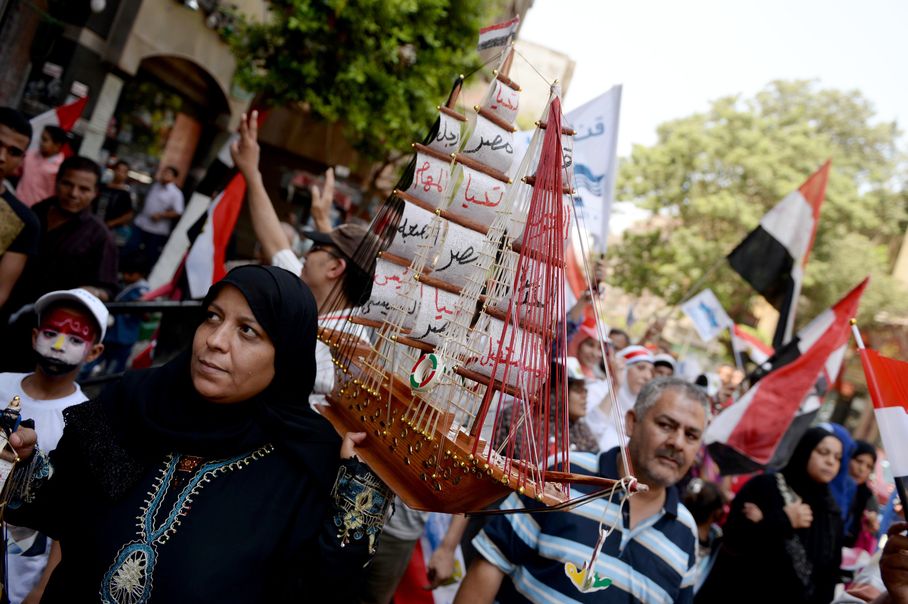  An Egyptian woman holds a small boat as she and other Egyptian's celebrate the new Suez Canal opening in Tahrir square in Cario, Egypt, Thursday, Aug. 6, 2015. Credit: Mohamed Hossam/ AP