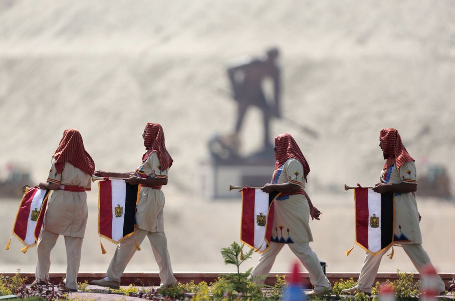 Egyptians wear Pharaonic costumes as they march in front of a statue representing a man digging the new section of the Suez Canal in Ismailia, Egypt, Thursday, Aug. 6, 2015. Credit: Hassan Ammar/ AP
