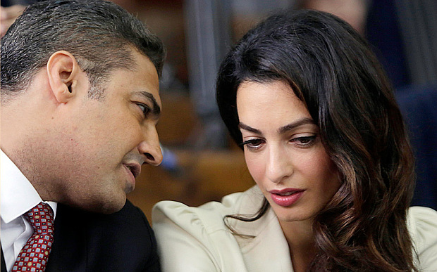 Al-Jazeera English journalist Mohammed Fahmy (left) talks to human rights lawyer Amal Clooney before his verdict in a courtroom in Tora prison in Cairo. Credit: Amr Nabil/ AP