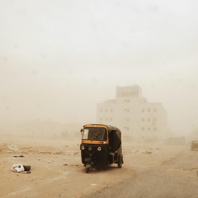A tuk-tuk riding through the haze o a sandstorm in October 6 City. Photo by Owise Abuzaid