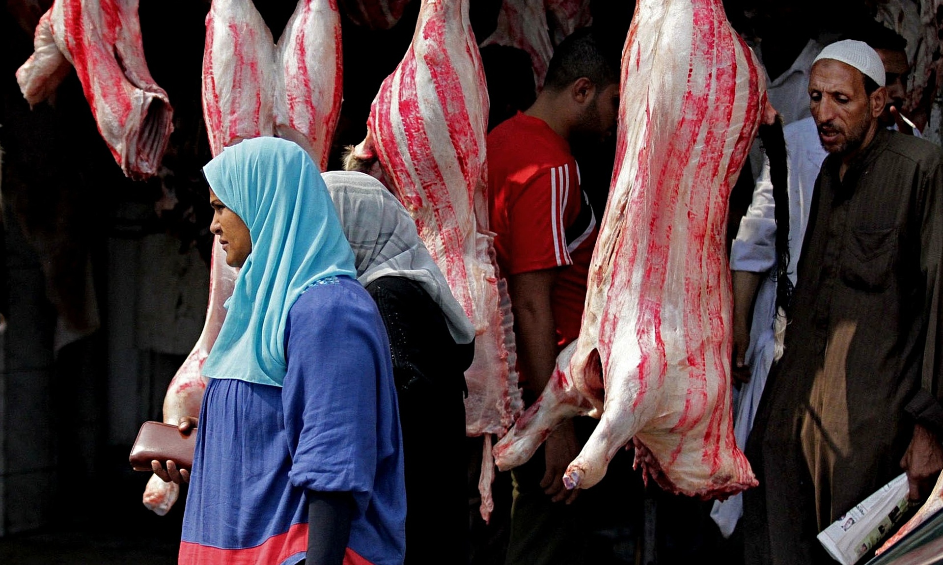  An Egyptian woman walks past meat displayed for sale in preparation for the Muslim holiday of Eid al-Adha at a market in Cairo in 2014. Photograph: Hussein Tallal/AP
