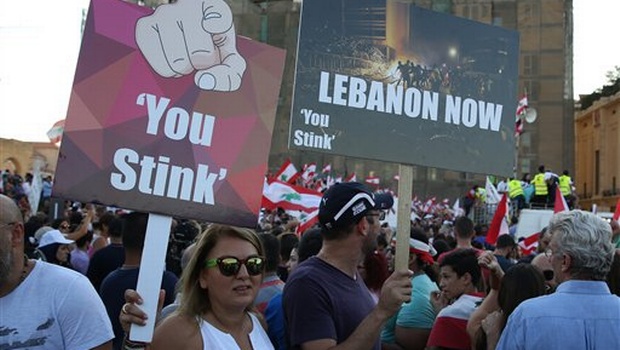 Lebanese anti-government protesters hold placards during a demonstration in Martyrs' Square, downtown Beirut, Lebanon. Credit: AP