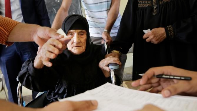 An elderly woman votes in Giza