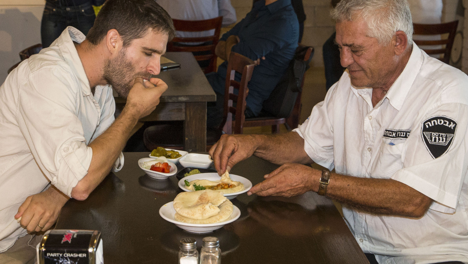 Israeli Jew David (L), 31, and Muslim Arab-Israeli Mahmoud, 62, share a plate of hummus at the Hummus bar. Photo: JACK GUEZ/AFP/Getty Images)