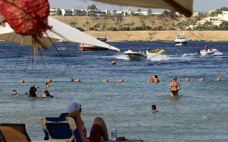 People enjoy the beach at the Red Sea resort of Sharm el-Sheikh in the South Sinai governorate, about 550 km (342 miles) south of Cairo, July 12, 2012. Egypt expects to receive more than 12 million tourists by the end of 2012, a 23 percent rise over the previous year, the tourism minister said on July 17, 2012, adding that he did not expect the election of a new Islamist president to stifle the industry. Picture taken July 12. REUTERS/Amr Abdallah Dalsh  (EGYPT - Tags: SOCIETY TRAVEL BUSINESS)