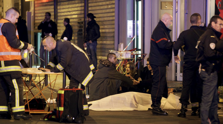 A general view of the scene that shows rescue services personnel working near the covered bodies outside a restaurant following a shooting incident in Paris, France, November 13, 2015. REUTERS/Philippe Wojazer 