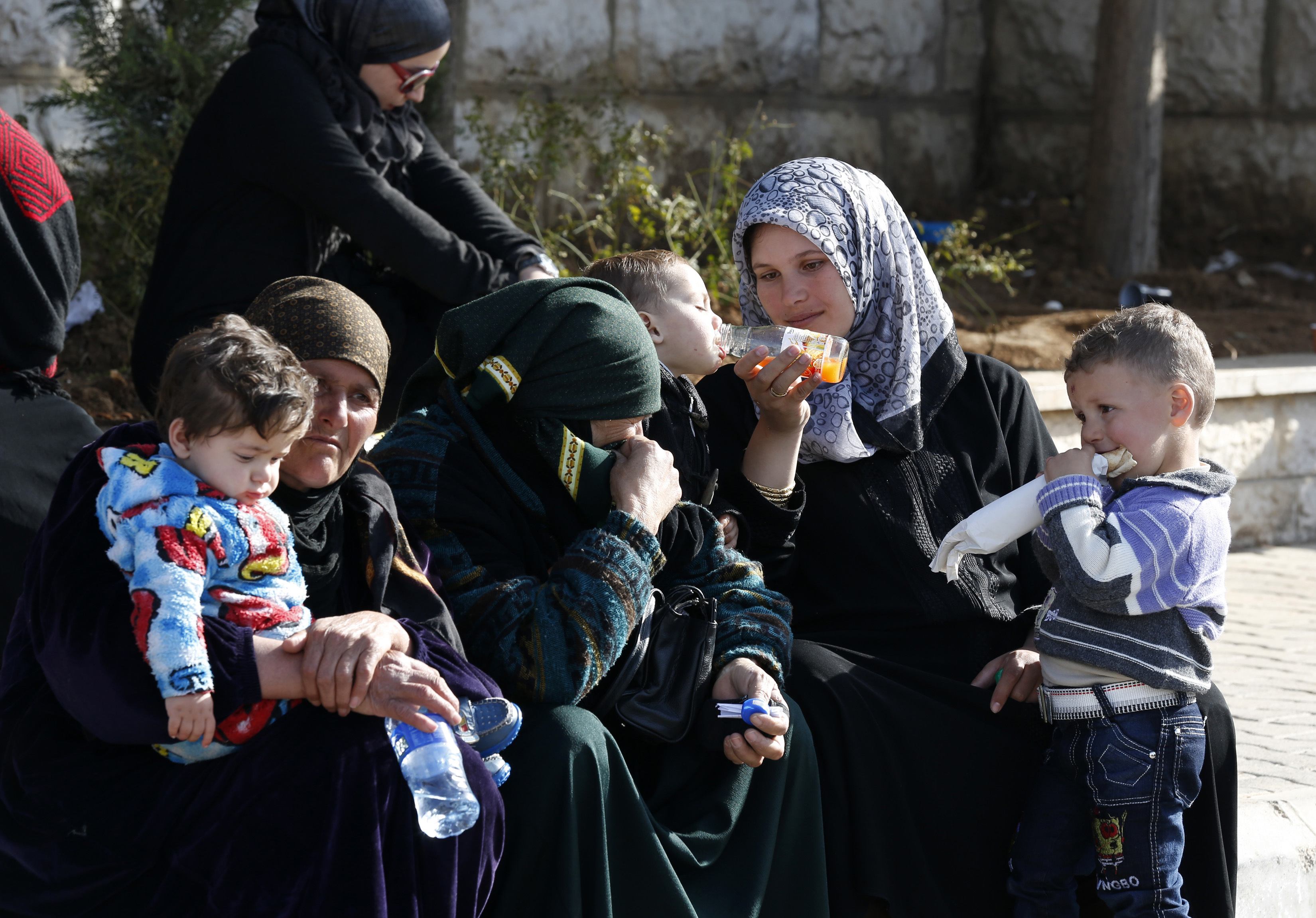 Syria women and children wait to get a visa stamp to enter Lebanon. Credit: Jamal Saidi/ Reuters
