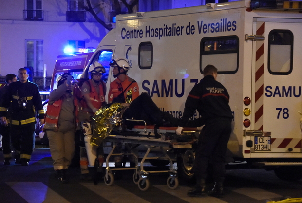 Firefighters and rescuers evacuate an injured person near the Bataclan concert hall in central Paris, on November 14, 2015. Photo: Dominique Faget, AFP