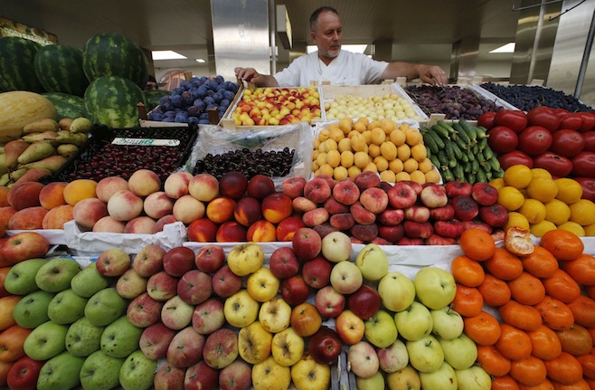 A vendor sells vegetables and fruits at the city market in St.Petersburg, Russia. PHOTO: Alexander Demianchuk/Reuters