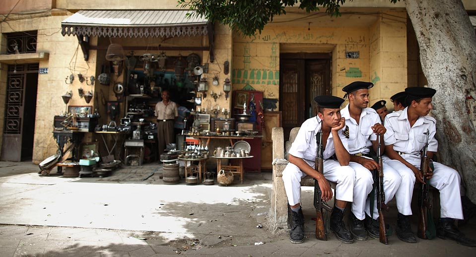 Tourist Police sit in the shade on a road leading to the Coptic Cairo area. Credit: Peter Macdiarmid/ Getty