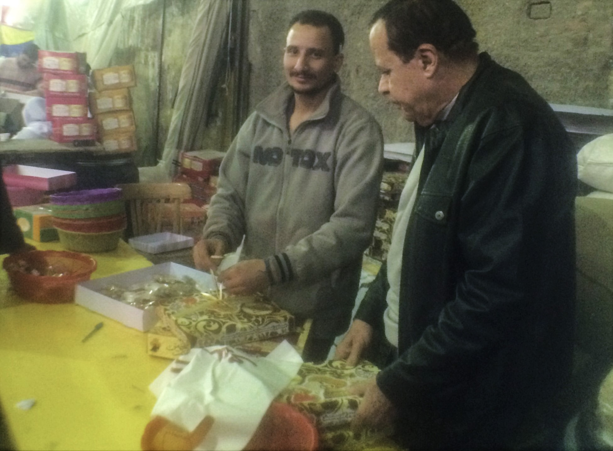 Packing el-Moulid sweets in Bein el-Harat Street. Phone photo by Nayrouz Talaat.