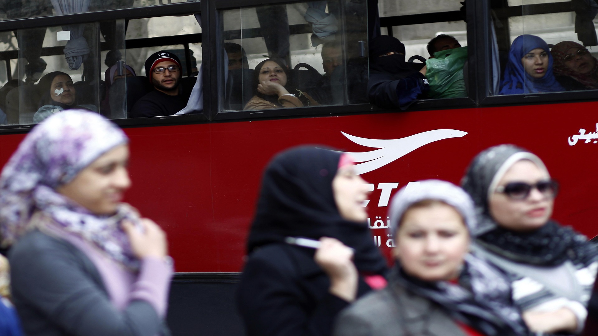 Egyptians ride in a bus past a polling station in central Cairo on December 15, 2012. (MAHMUD KHALED/AFP/Getty Images)