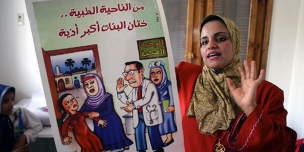 Mona Omar, a social worker, holds an FGM-awareness poster at a village meeting. Photo: Giacomo Pirozzi/UNICEF