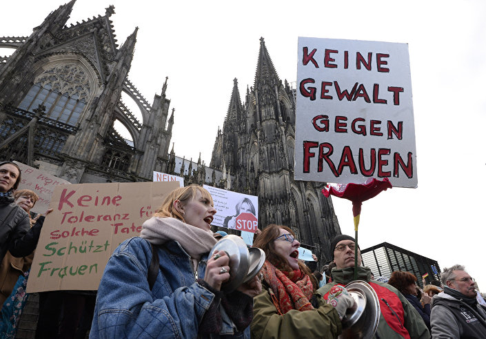 A man holds up a sign reading "No violence against women" as he takes part in a demonstration in front of the cathedral in Cologne, western Germany, on January 9, 2015 where sexual assaults in a crowd of migrants took place on New Year's Eve. Photo: AFP 