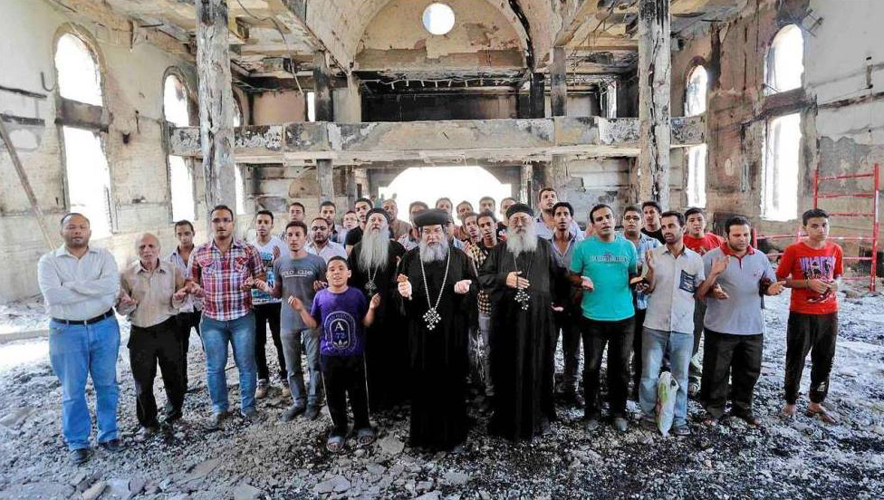 Coptic Christians pray in a burned church in Egypt in 2013.